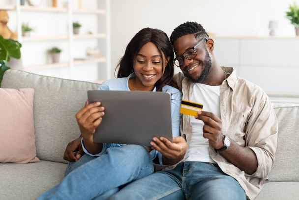 Black couple using pc and debit credit card at home - Φωτογραφία, εικόνα