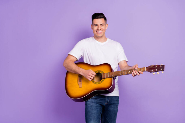 Photo of young man happy positive smile play guitar concert artist isolated over violet color background - Photo, image