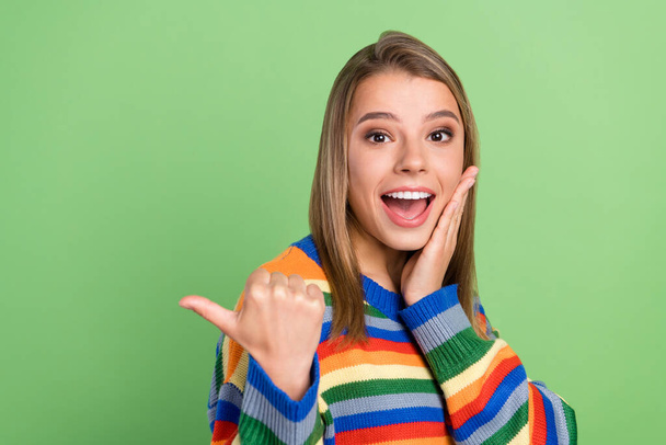 Photo portrait girl showing copyspace thumb amazed overjoyed isolated pastel green color background - Photo, image