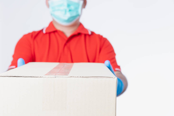 Delivery man wearing medical mask and gloves holding box package Isolated on white studio background with copy space. Online shopping concept. - Φωτογραφία, εικόνα
