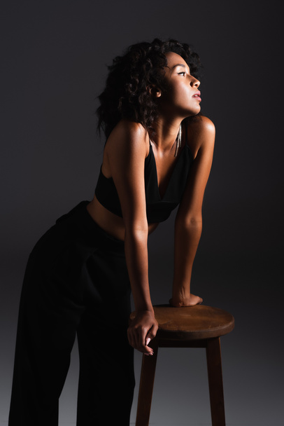 joven afroamericana mujer en sexy crop top y pantalones en negro - Foto, Imagen
