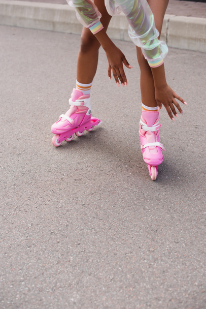 vista parcial de la mujer afroamericana patinando en patines de ruedas afuera - Foto, Imagen