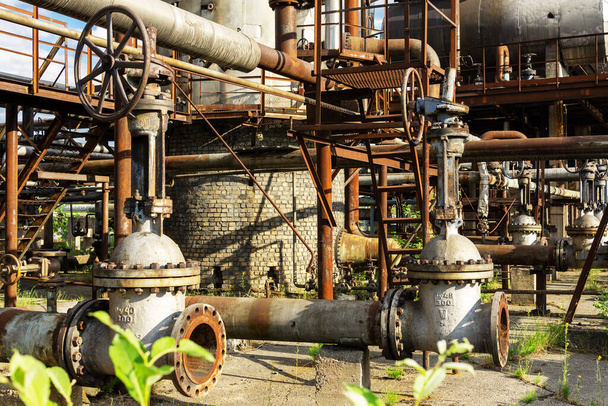 Les vieilles vannes rouillées sont des verrous sur le pipeline d'une usine chimique abandonnée . - Photo, image