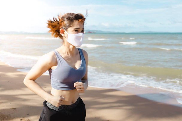 Woman jogging by the beach in the morning of warm summer. - Foto, Imagen
