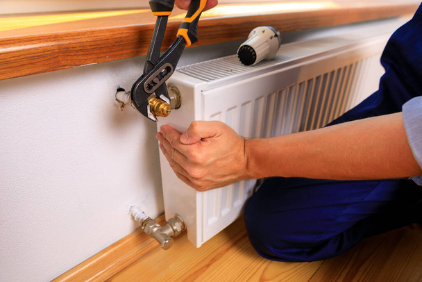 Repair heating radiator close-up. man repairing radiator with wrench. Removing air from the radiator - Foto, Imagem