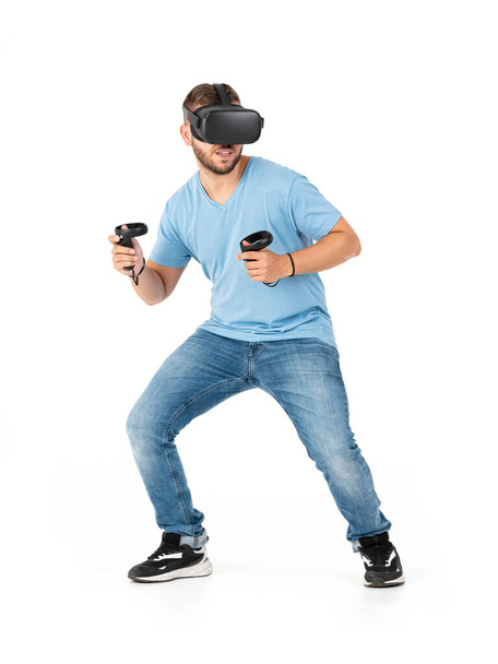 Young man playing with a VR glasses on a white background - Photo, Image