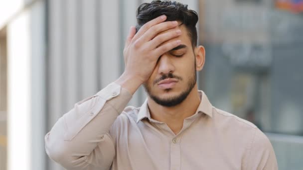Arabian hispanic man bearded guy businessman have problem boss looser failure badly news feels frustrated cover face with palm looks very disappointed lost trouble unpleasant face outdoors in city - Footage, Video