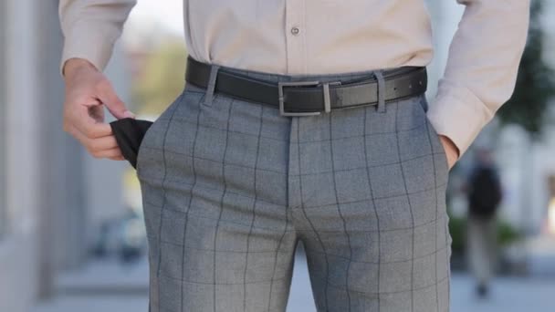 Close up male plaid pants. Man shows empty pockets standing outdoors isolated in city, poor bankrupt, no money financial crisis. Business bankruptcy debt problems, the guy suffers from unemployment - Footage, Video