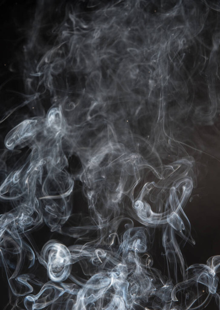 Abstract puffs of smoke on a black background. - Foto, imagen