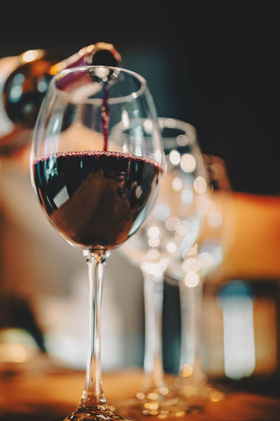 bartender pouring red wine into a glass in cafe or bar - Photo, Image