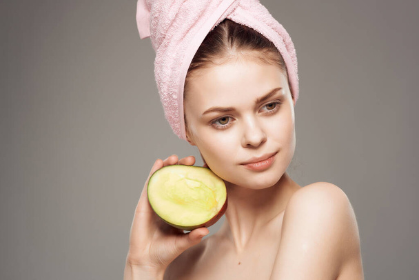 mujer con una toalla en la cabeza mango de piel limpia en la mano - Foto, imagen
