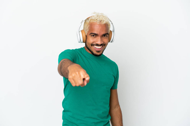 Nuori Kolumbian komea mies eristetty valkoisella taustalla kuuntelee musiikkia - Valokuva, kuva