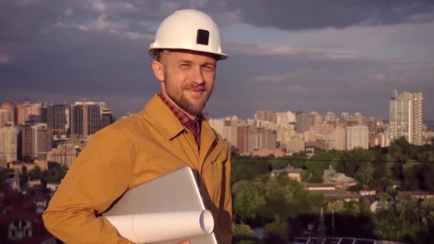 Foreman, supervisor portret in helm en laptop, uitzicht op de stad - Video
