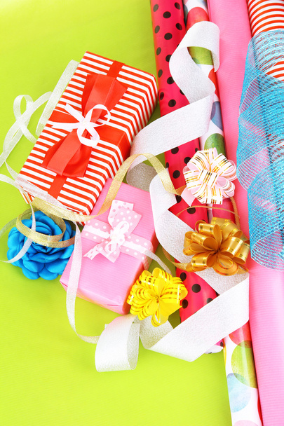 Rolls of Christmas wrapping paper with ribbons, bows on color background - Фото, зображення