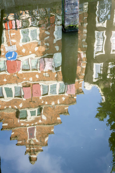 Spiegelbild Reflexion skurrile und ungewöhnliche Stufenfassade eines sechsstöckigen Gebäudes in der Straße von Amsterdam - Foto, Bild