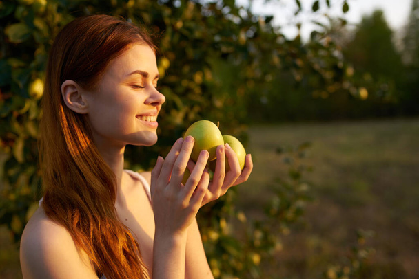 mujer alegre en la naturaleza cerca del manzano descansan los frutos - Foto, Imagen