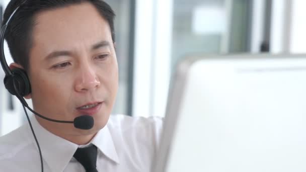 Podnikatel ve sluchátkách aktivně pracuje v kanceláři - Záběry, video
