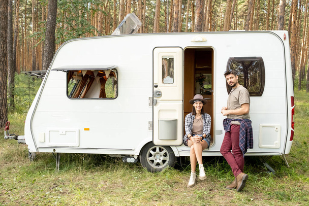Happy young couple having rest by house on wheels - Fotografie, Obrázek