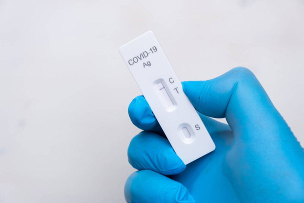 Negatywny wynik testu antygenowego Covid-19 na szybkie wykrycie choroby u lekarzy w gumowych rękawiczkach z miejscem do kopiowania. Kaseta testowa koronawirusa z szybkiego zestawu do strepu.  - Zdjęcie, obraz