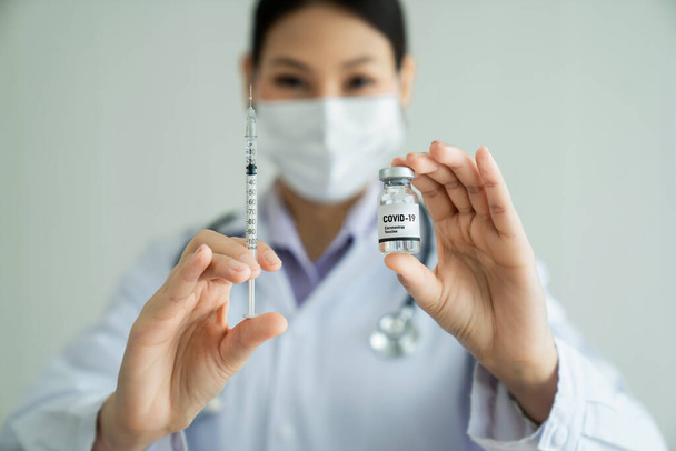 Taitava lääkäri valmistaa rokotteen taidokkaasti ennen injektiota - Valokuva, kuva