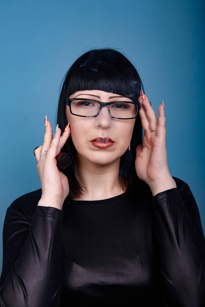 portrait of a beautiful girl with glasses posing for a photographer in the studio - 写真・画像
