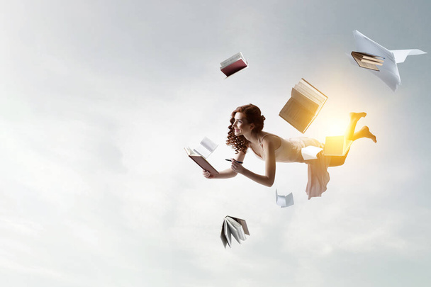 Young woman levitates while reading a book - Zdjęcie, obraz