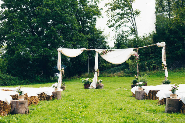 A beautiful outdoor wedding altar in nature with wooden log seats on a sunny day - Photo, image
