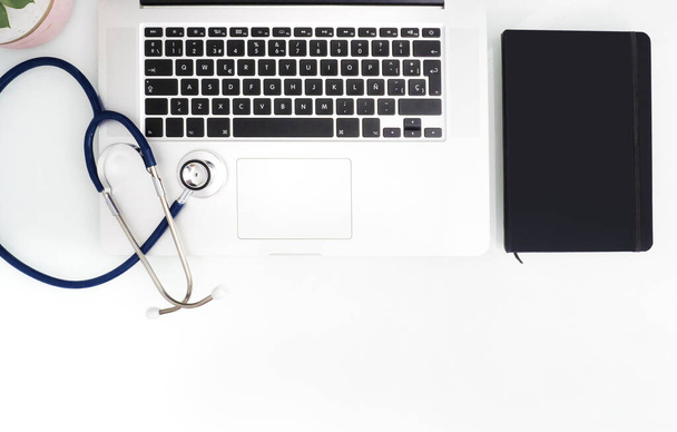 Stethoscope, laptop and notebook on white table with copy space. Medical concept. - 写真・画像