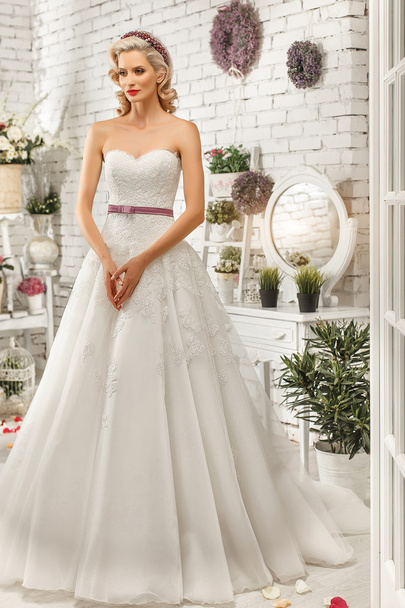 The beautiful  woman posing in a wedding dress - Foto, imagen