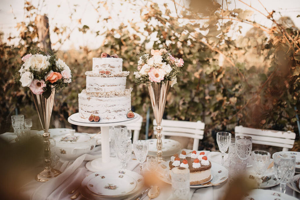 A closeup of the wedding table with cake and flowers. - Zdjęcie, obraz