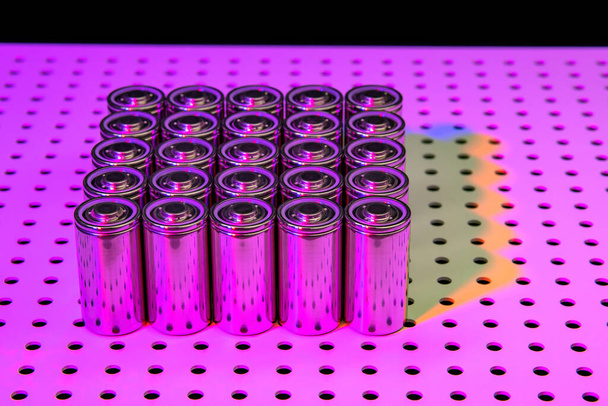 New modern lithium-ion batteries with increased capacity. A prototype of new batteries on a laboratory table illuminated by an ultraviolet lamp. - Fotografie, Obrázek