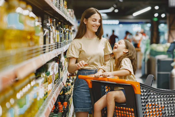 The family buys groceries at the supermarket - 写真・画像