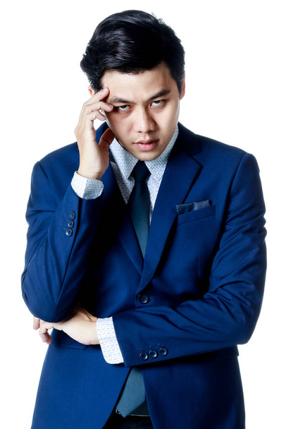 Joven atractivo hombre de negocios asiático vistiendo traje azul marino con camisa blanca y corbata puso su mano en su cabeza buscando decepcionado y estresante. Fondo blanco. Aislado - Foto, imagen