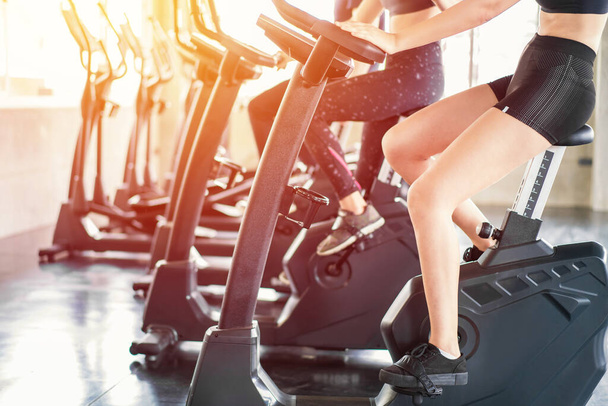 Beautiful sport woman working out on exercise bike at sport health club. - Photo, Image
