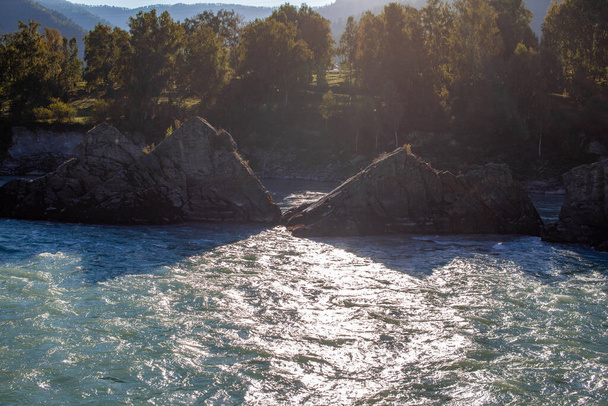 Ein schnell fließender breiter und voll fließender Gebirgsfluss. Große Felsen ragen aus dem Wasser. Großer Gebirgsfluss Katun, türkisfarben, im Altai-Gebirge, Republik Altai. - Foto, Bild