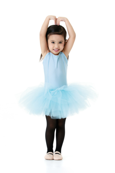 Retrato aislado estudio disparo de poco lindo preescolar pigtails peinado bailarina bailarina chica en azul tutú ballet vestido negro legging y zapatos traje de pie sonriendo posando sobre fondo blanco. - Foto, imagen