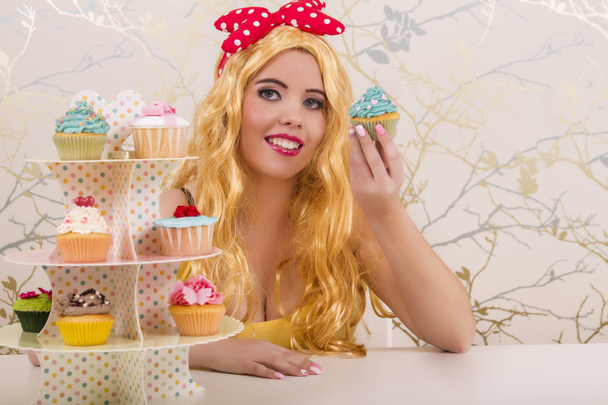 Hermosa chica pelirroja pinup con cupcakes de colores
 - Foto, imagen