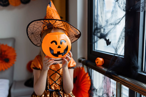 Little Girl in costume of which in decorated bedroom at home. Happy Halloween concept - Foto, Bild