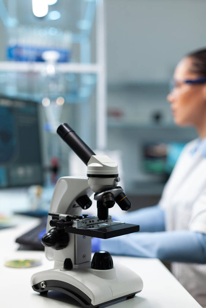 Сосредоточение внимания на медицинском микроскопе, стоящем на столе в лаборатории биохимической больницы - Фото, изображение