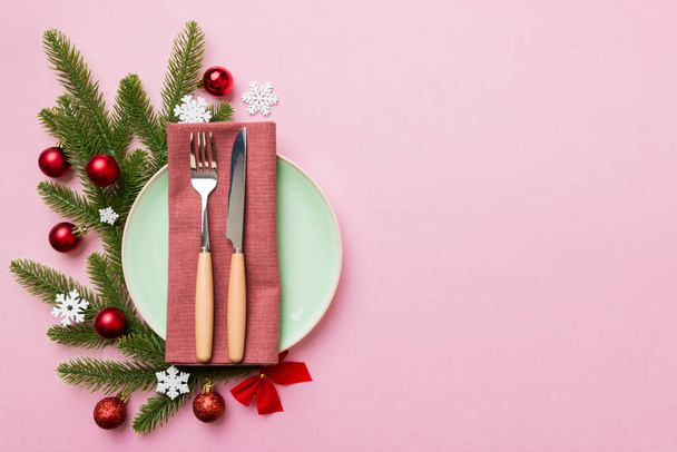 Weihnachtliche Tischdekoration mit Weihnachtsdekoration und Tellern, Kinn, Gabel und Löffel. Weihnachtsfeiertag Hintergrund. Draufsicht mit Kopierraum. - Foto, Bild