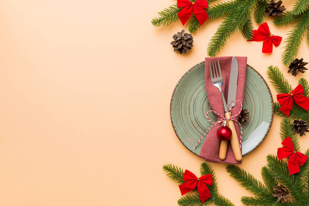Kerst tafelschikking met kerst decor en borden, koeien, vork en lepel. Kerstvakantie achtergrond. Bovenaanzicht met kopieerruimte. - Foto, afbeelding