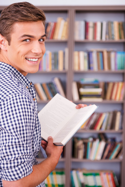 Happy young man holding book - Фото, изображение