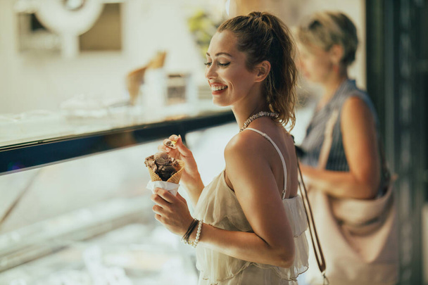 Retrato de una joven atractiva disfrutando de un helado. - Foto, Imagen