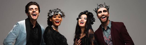 веселі багатоетнічні друзі в костюмах Хеллоуїна сміються на камеру ізольовані на сірому, банер
 - Фото, зображення