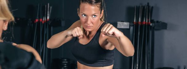 Жінка тренує жорсткий бокс в тренажерному залі
 - Фото, зображення