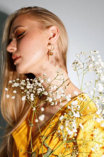 model blonde fashion blogger with flowers and earrings in her ears. close-up - Φωτογραφία, εικόνα
