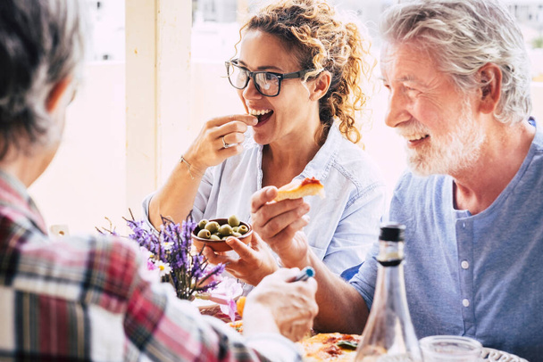 People having fun and having lunch on dining table. Spending quality time with family and friends. Loving happy multi generation family enjoying together food and drinks - Foto, imagen