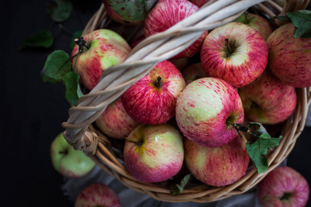 Fresh ripe autumn red apples in basket on rustic background - Fotoğraf, Görsel