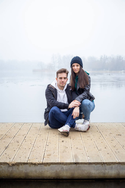Genç çift, Macaristan 'ın Zalaegerszeg kentinde sisli bir kış gününde Gebart Gölü' nde birlikte vakit geçiriyorlar. - Fotoğraf, Görsel