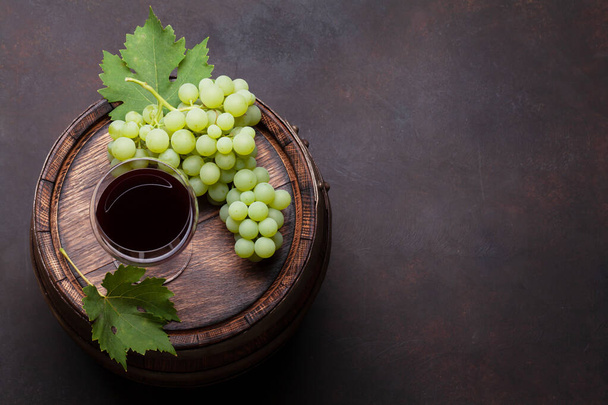 White grape and red wine glass on old wooden wine barrel. Top view flat lay with copy space - Photo, Image